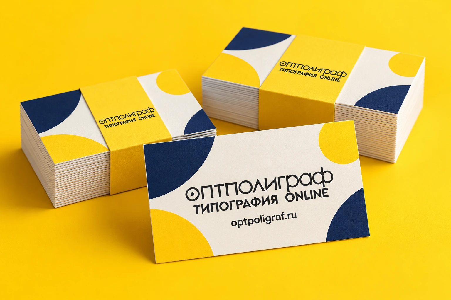 Стопки бумажных визиток с фирменным логотипом ОптПолиграф на жёлтом фоне